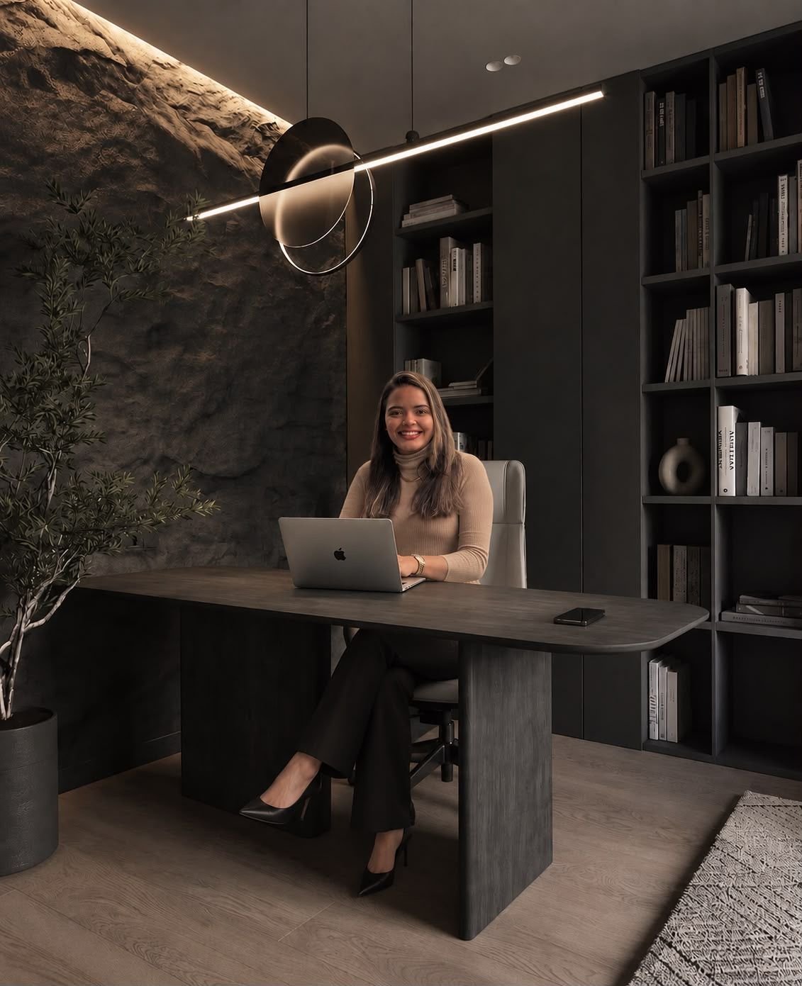 Sarah Caroline de Andrade Firmino em seu escritório, sentada à mesa de trabalho